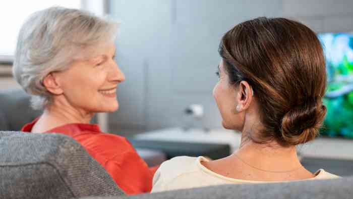 Vrouw op de bank wijst naar haar oor