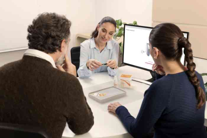 een stel krijgt uitleg over het schoonmaken van hoortoestellen