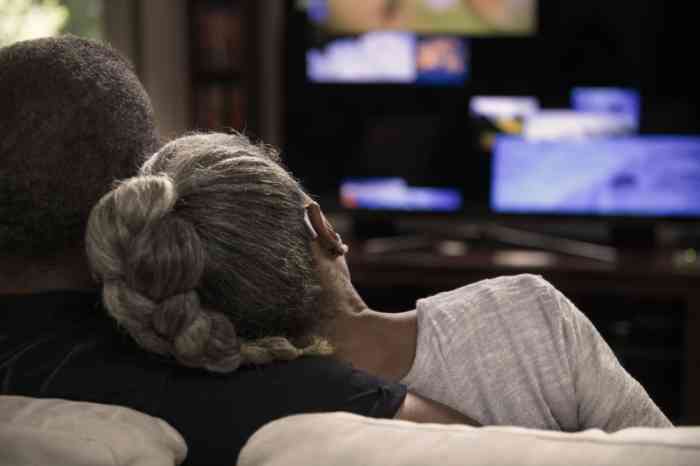 Man en vrouw kijken naar TV met ringleiding