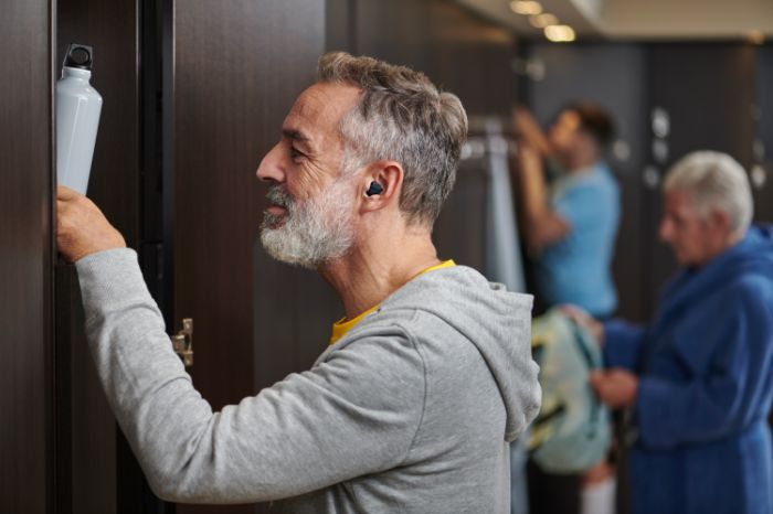 Man met in-het-oor oplaadbaar hoortoestel