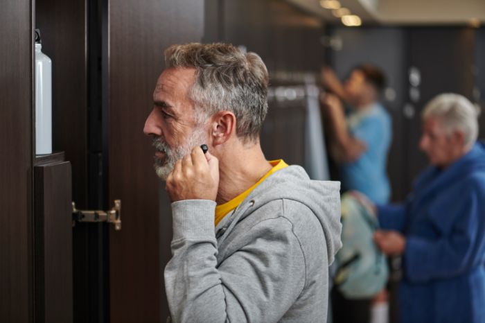 Man doet Bluetooth hoortoestel in