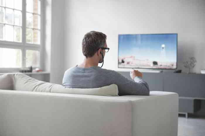 Man met Sennheiser koptelefoon kijkt TV
