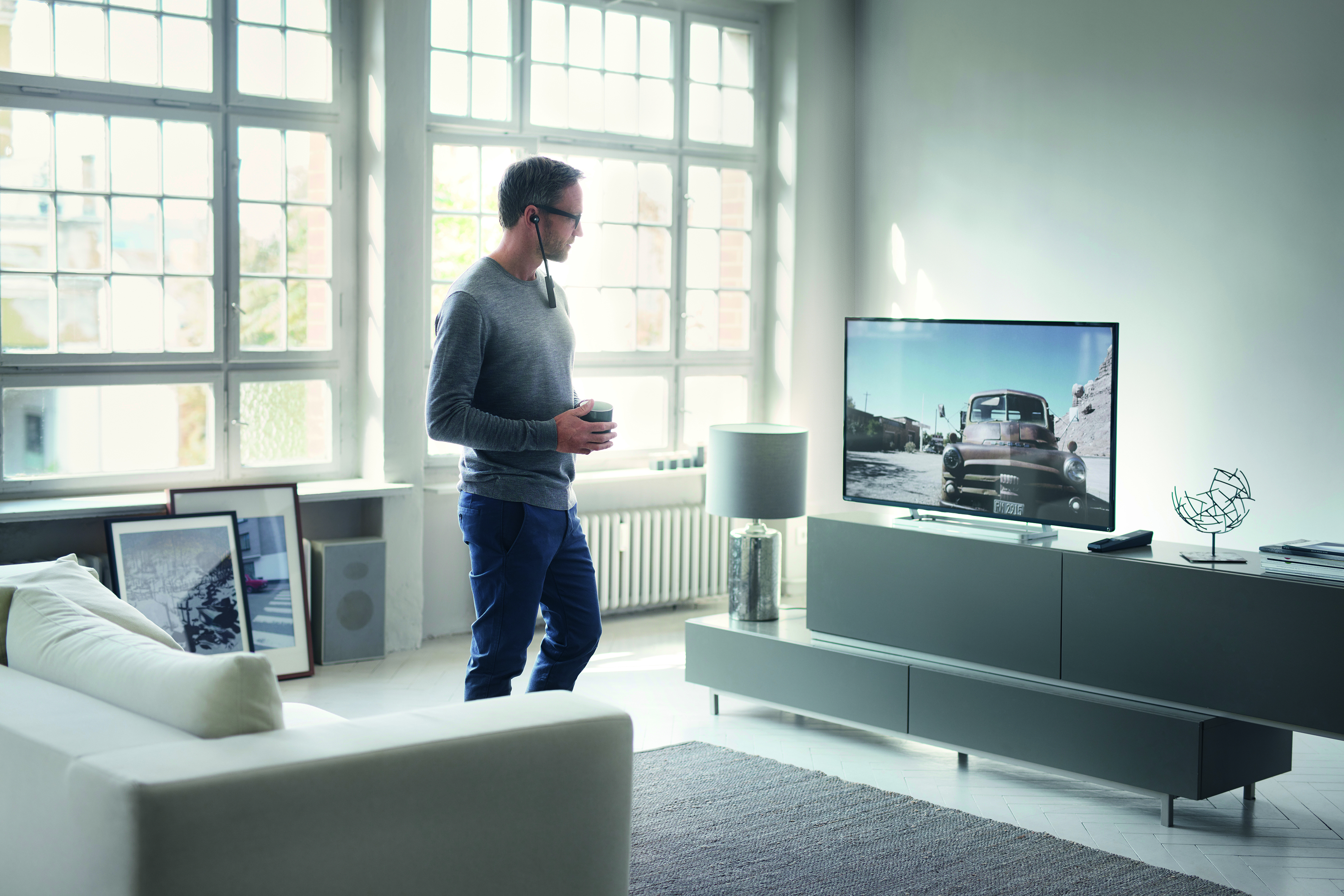 Man met Sennheiser koptelefoon kijkt TV 