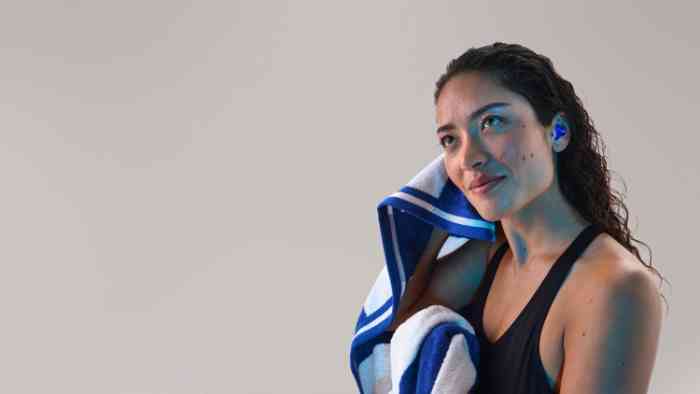 Vrouw met gehoorbescherming op maat in zwembad