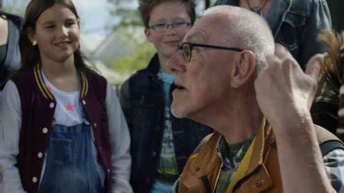 Man met hoortoestellen luistert aandachtig naar kinderen 