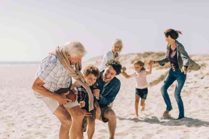 Opa met hoortoestel met kinderen en kleinkinderen op het strand